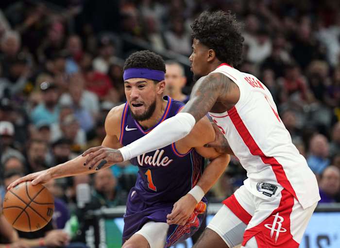 Suns guard Devin Booker (1) dribbles against Houston Rockets guard Jalen Green (4) during the second half at Footprint Center.